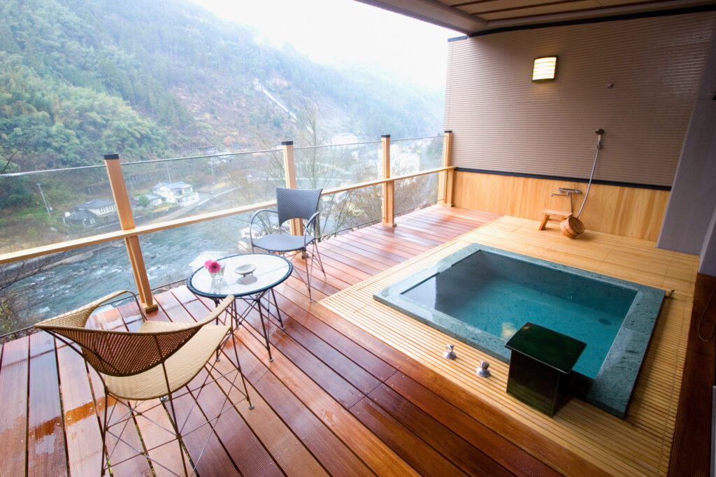 Private outdoor hot spring bath on a guest room balcony overlooking surrounding nature - Bespoke Japan Tour Experience by Japan Navi Journey