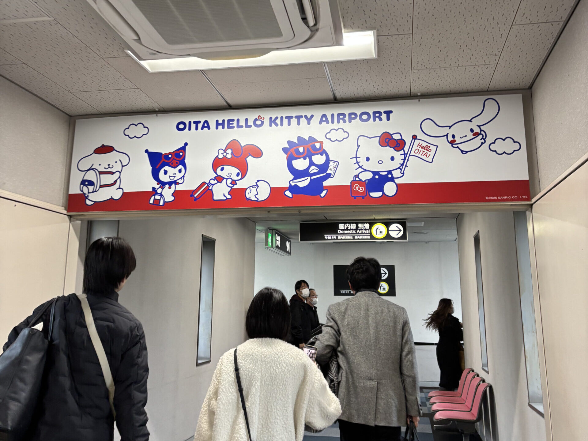Cute Hello Kitty collaboration board hanging overhead inside Oita Airport - Japan Navi Journey